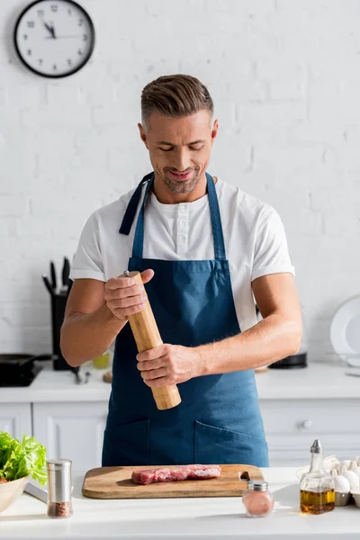 Przystojny Uśmiechnięty Mężczyzna Przypraw Stek Przed Gotowaniem — Zdjęcie stockowe