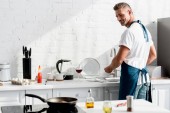 dospělý muž mytí nádobí v kuchyni