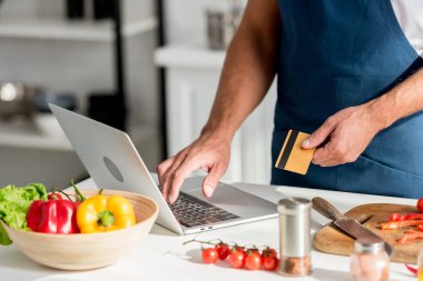 adamın üstünde laptop online alışveriş yaparken önlük kısmi görünümü