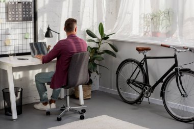 arkadan iş yerinde oturan ve office evde pencereden dışarı bakarak adam görünüşü