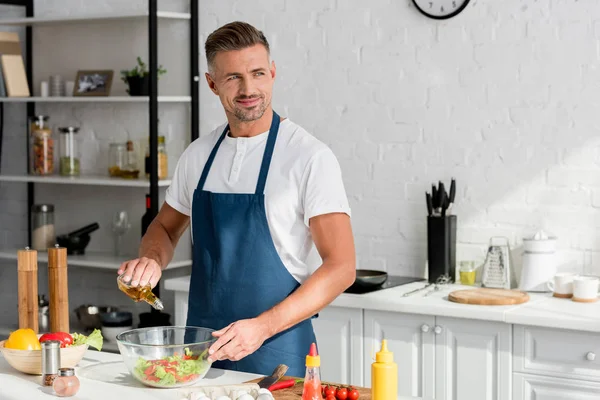 Adulto Sonriente Hombre Añadir Aceite Ensalada Cocina — Foto de Stock