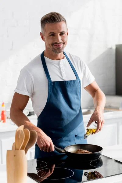 Volwassene Glimlachende Man Stromende Olie Biefstuk Keuken — Stockfoto