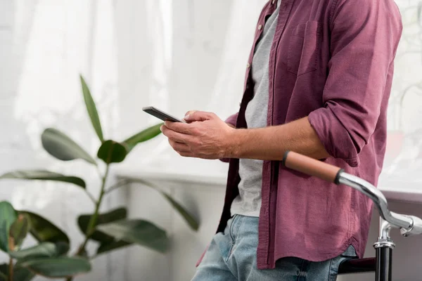 Smartphone Kullanarak Evde Bisiklet Üzerinde Office Eğilerek Adam Görünümünü Kırpılmış — Ücretsiz Stok Fotoğraf