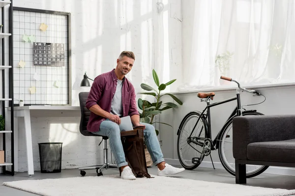 Mann Sitzt Auf Stuhl Und Steckt Laptop Tasche Home Office — Stockfoto