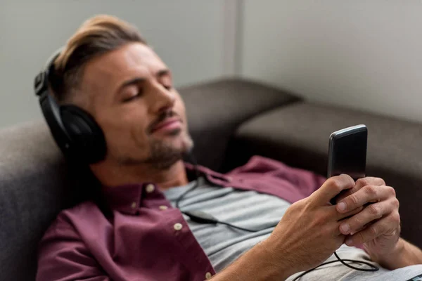 Happy Man Smartphone Closed Eyes Listening Music While Laying Sofa — Stock Photo, Image