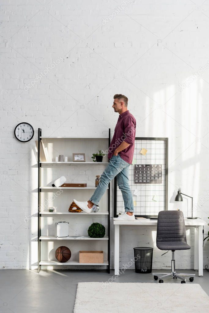 man stepping from desk at home office