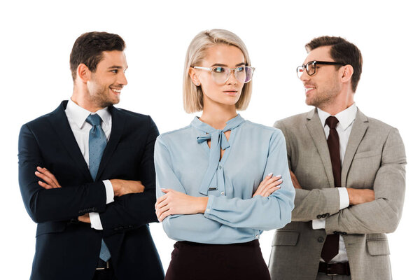 cheerful businessmen standing with arms crossed behind serious businesswoman isolated on white 