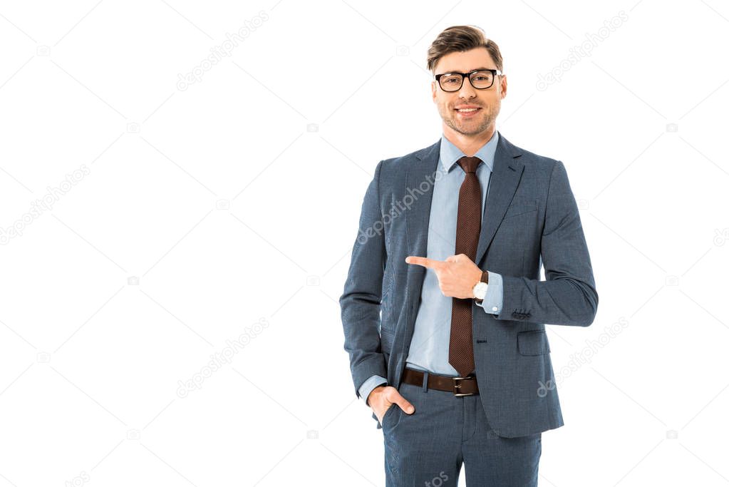 smiling businessman in glasses and suit pointing sideways isolated on white