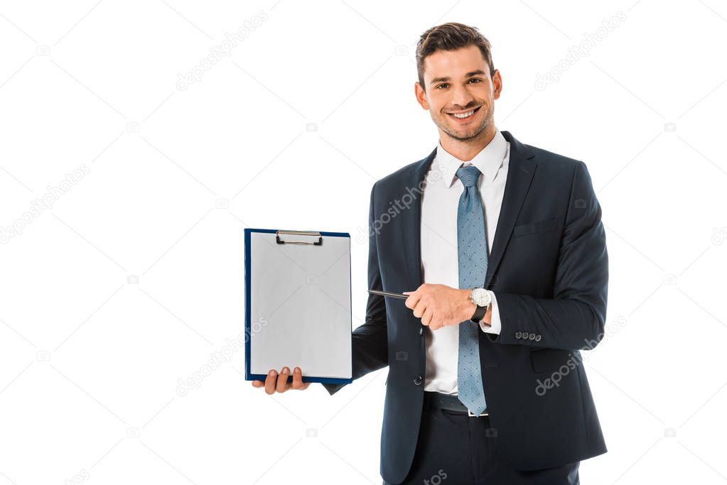 smiling businessman in suit pointing at empty clipboard isolated on white 