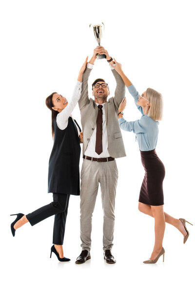 successful businessman holding up trophy cup while female colleagues trying to get it isolated on white
