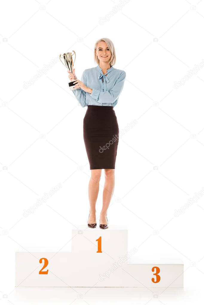successful businesswoman with trophy cup standing on winners podium isolated on white