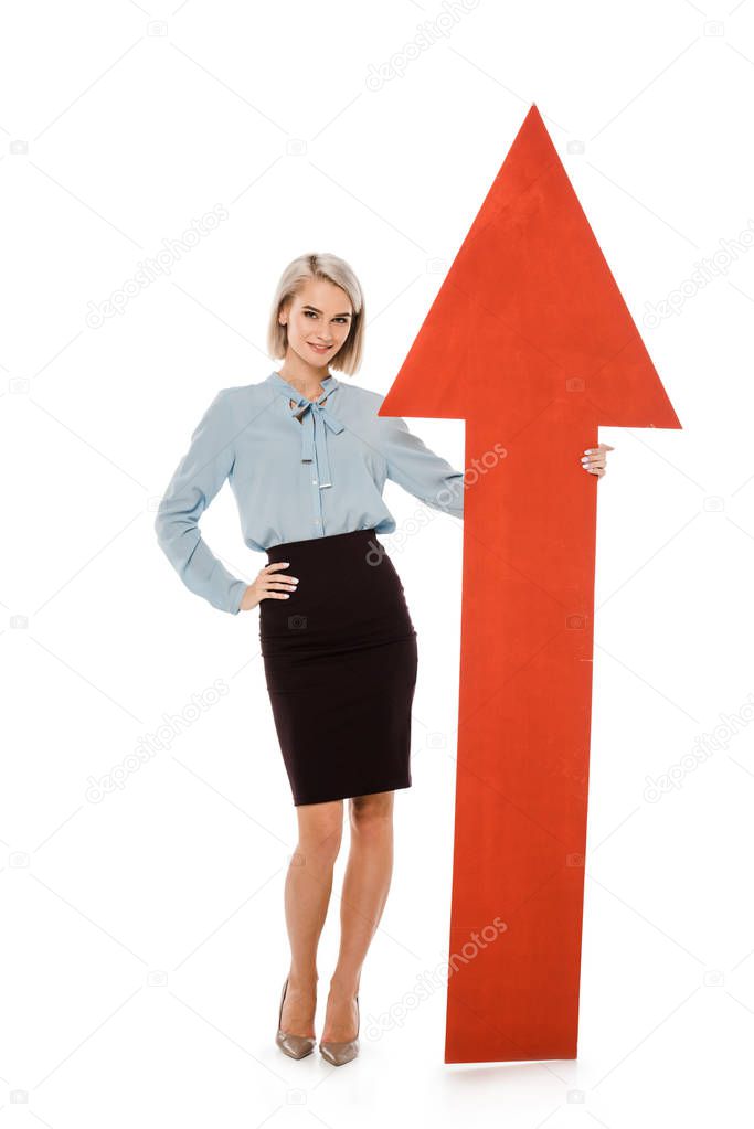 young businesswoman standing with big red arrow isolated on white