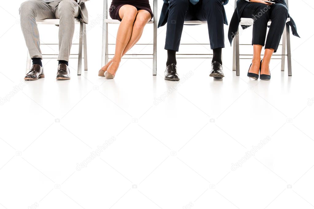low section view of business group sitting on chairs isolated on white