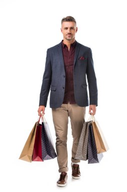 renkli alışveriş torbaları üzerinde beyaz izole tutan ceketli şık yetişkin adamı