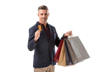 kredi kartı üzerinde beyaz izole gösteren alışveriş torbaları ile yetişkin yakışıklı adam