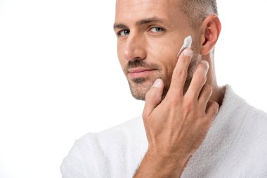 beyaz izole yüz güzellik krem uygulayarak bornoz yetişkin yakışıklı adam