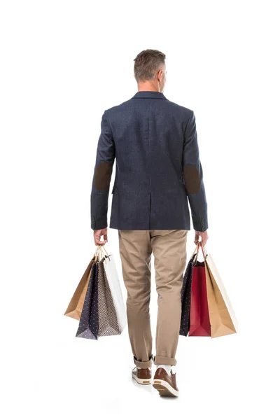 时尚男子的后视镜在夹克举行五颜六色的购物袋孤立在白色 — 图库照片