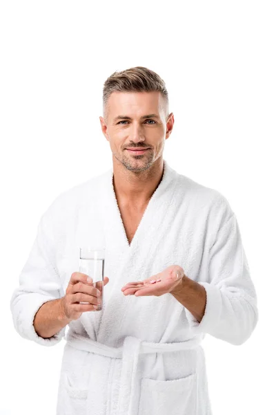 Hombre Sonriente Albornoz Sosteniendo Píldoras Vaso Agua Aislado Blanco — Foto de stock gratis