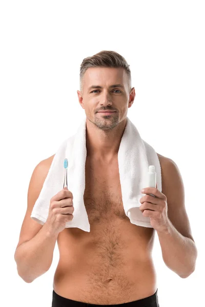 歯ブラシと歯磨き粉を白で隔離を保持している首の上のタオルで幸せな成人男  — 無料ストックフォト