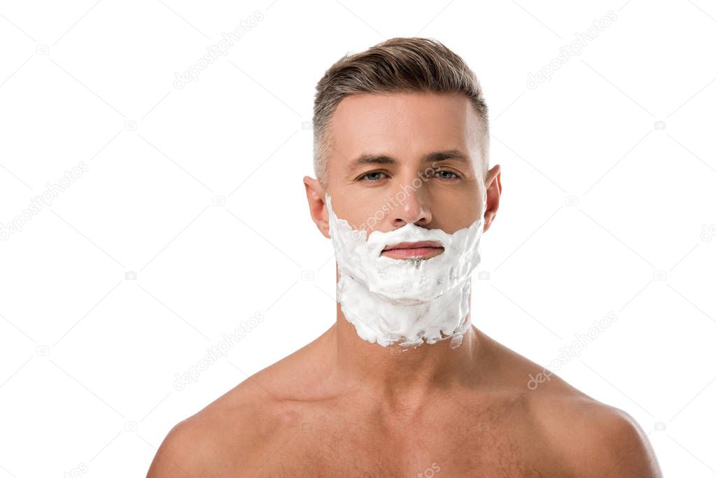 portrait of adult man with shaving foam on face looking at camera isolated on white