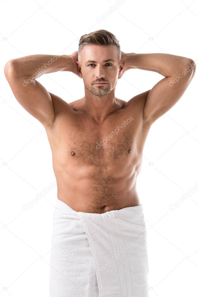adult muscular shirtless man wrapped in towel posing with raised arms isolated on white