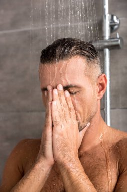 yetişkin adamın yüzündeki sabah duş alırken elleri ile seçici odak 