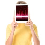 Attraktive junge Frau hält ein digitales Tablet mit Diagrammen auf dem Bildschirm, isoliert auf weiß