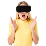 Shocked young woman using virtual reality headset isolated on white