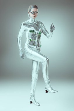 full length view of silver cyborg walking on grey, future technology concept  clipart