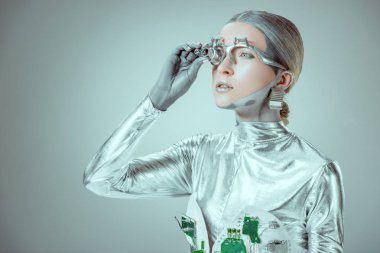fütüristik gümüş robot göz protezi ayarlama ve dış saha üzerinde izole gri, geleceğin teknolojisi kavramı arıyorsunuz  