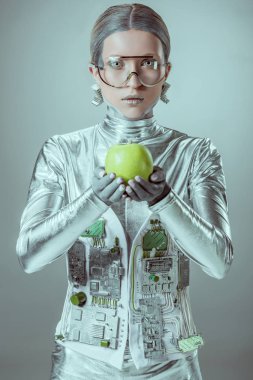 elma tutarak ve izole gri, geleceğin teknoloji kavramı üzerinde kamera bakarak fütüristik gözlük cyborg 