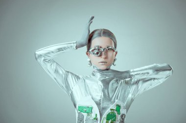 Genç kadın robot izole gri, geleceğin teknoloji kavramı üzerinde kamera bakıyor