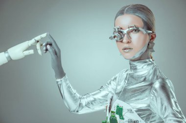 Robotik kol dokunmaktan ve izole gri, geleceğin teknoloji kavramı üzerinde kamera bakarak cyborg