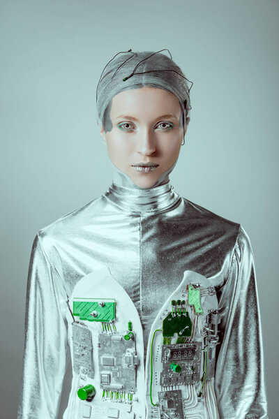 futuristic silver female cyborg looking at camera isolated on grey, future technology concept