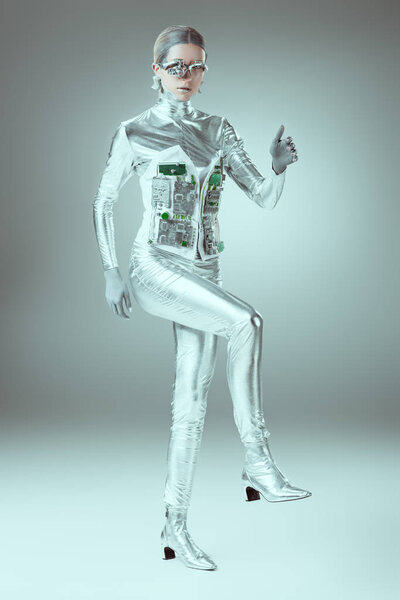 full length view of silver cyborg walking on grey, future technology concept 