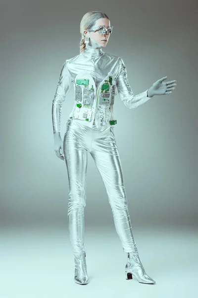 full length view of silver woman robot standing on grey, future technology concept