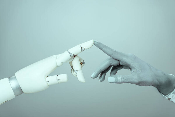 cropped shot of cyborg touching robotic arm isolated on grey, future technology concept