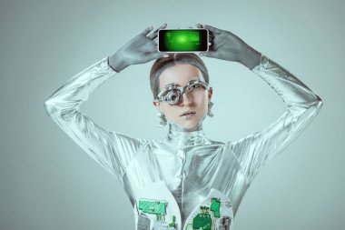 grafikler pazarlama ve izole gri, geleceğin teknoloji kavramı üzerinde kamera bakarak iş ile akıllı telefon tutarak robot    
