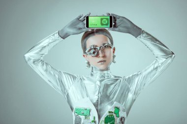 web alışveriş uygulaması ve izole gri, geleceğin teknoloji kavramı üzerinde kamera bakarak sahip holding robot   