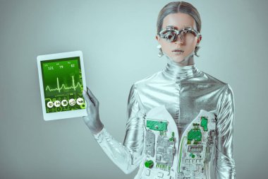 Gümüş robot holding tablet ile tıbbi cihaz izole gri, geleceğin teknoloji kavramı üzerinde