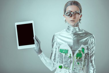 Gümüş robot tablet boş ekran ile tutarak ve izole gri, geleceğin teknoloji kavramı üzerinde kamera bakıyor