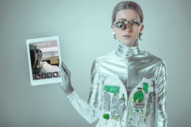 Gümüş robot holding tablet izole gri, geleceğin teknoloji kavramı üzerinde bilet cihazı ile