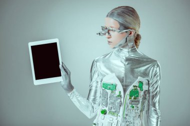 Gümüş robot holding tablet ile izole gri, geleceğin teknoloji kavramı üzerinde boş perde