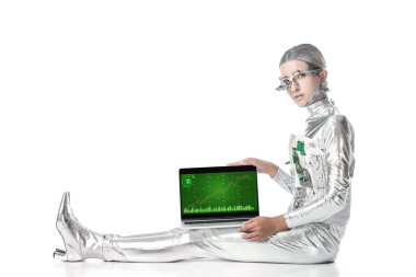 oturma ve izole beyaz, geleceğin teknoloji kavramı üzerinde grafik cihazı ile dizüstü bilgisayarı gösteren gümüş robot