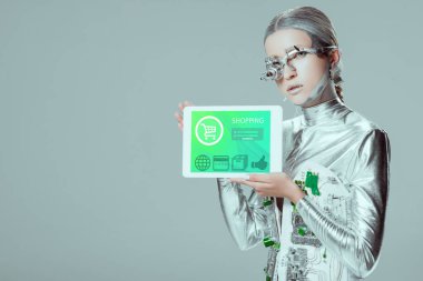 Gümüş robot tablet cihaz izole gri, geleceğin teknoloji kavramı üzerinde alışveriş ile tutarak