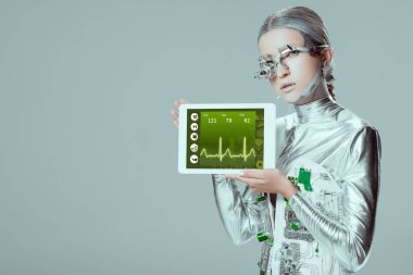 Gümüş robot holding tablet ile tıbbi cihaz izole gri, geleceğin teknoloji kavramı üzerinde