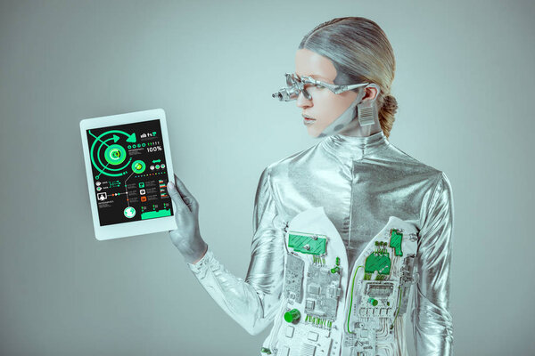 silver robot looking at tablet with infographics appliance isolated on grey, future technology concept