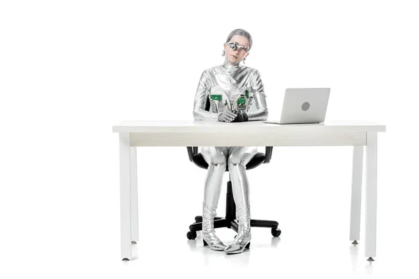 Robot Plateado Sentado Mesa Con Ordenador Portátil Aislado Blanco Concepto —  Fotos de Stock