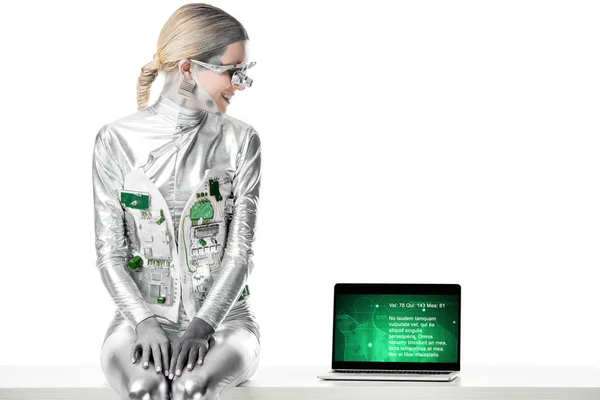 Smiling Silver Robot Sitting Table Looking Laptop Medical Appliance Isolated — Stock Photo, Image