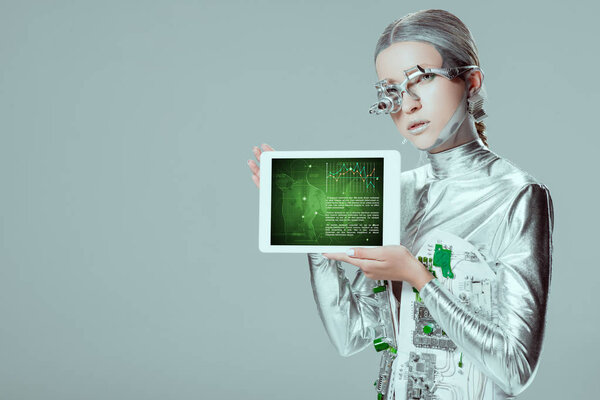 Серебряный робот держит планшет с медицинским прибором, изолированным на сером, концепция технологии будущего
